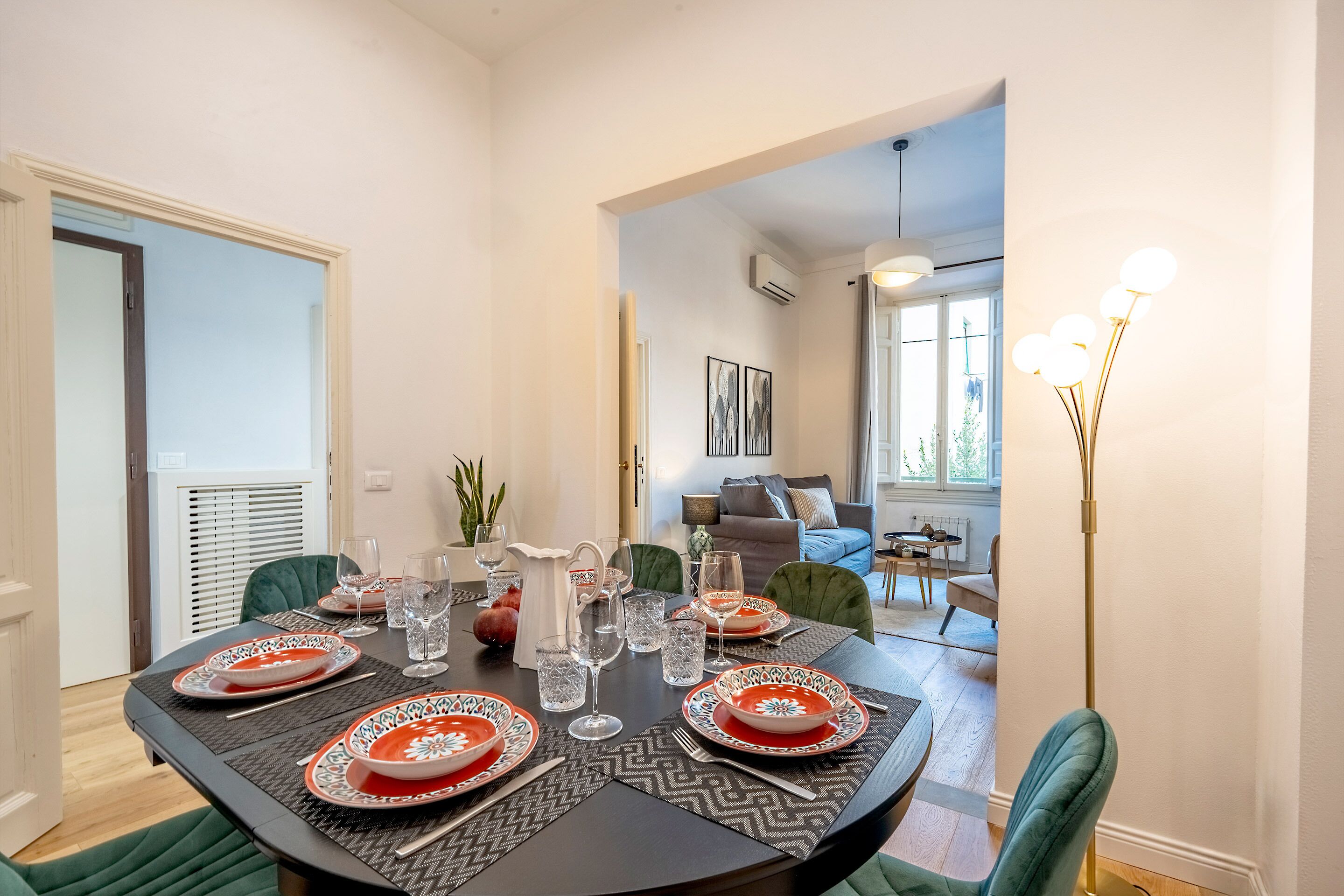 A dining area with a round table set for four, featuring patterned tablecloths and matching plates.