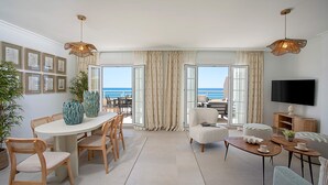 Un grand salon comprenant un coin repas, un canapé et un téléviseur.