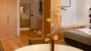 Et moderne soveværelse med en seng, et natbord og en vase med blomster.