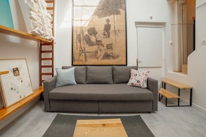 A modern living room with a grey sofa, a wooden coffee table, and a large abstract painting on the wall. - Clerigos Loft by Hosty (Oporto)