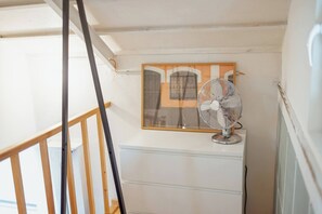 A room with a white dresser, a standing fan, and a framed picture on the wall. - Clerigos Loft by Hosty (Oporto)