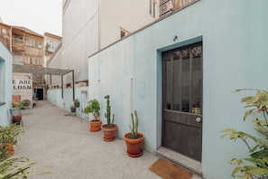 A narrow alleyway with potted plants and a sign that reads "E ARE LOAN". - Clerigos Loft by Hosty (Oporto)
