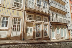 Um edifício com várias janelas, uma porta com um letreiro e uma parede com padrão.