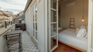 Ein Zimmer mit einem Bett, einer Holzleiter und einem kleinen Tisch mit einer Bank.