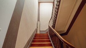 A wooden staircase with a handrail, leading to a door at the top. - Downtown Bolhão 3 by Hosty (Porto)