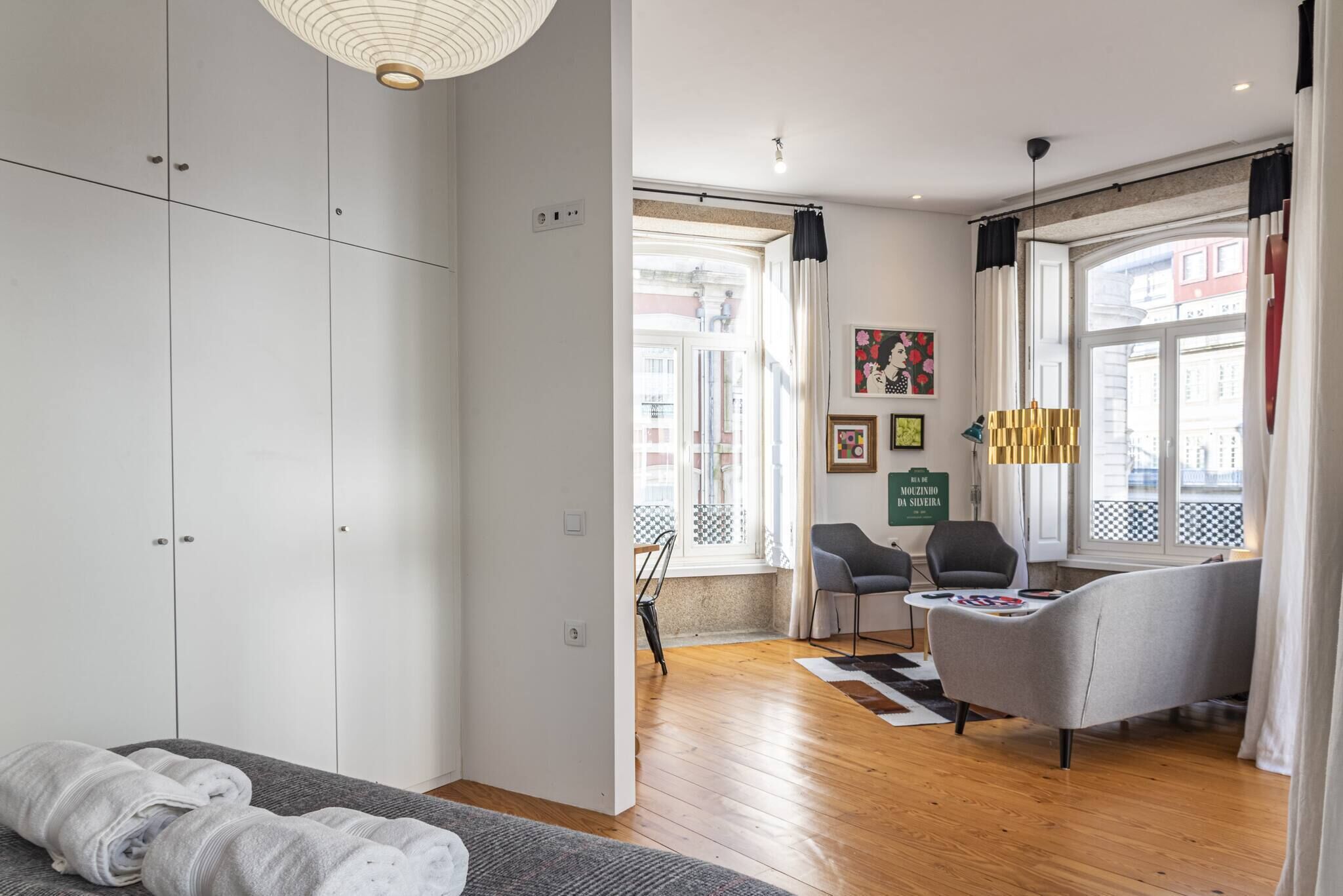 A modern living room with a sofa, chairs, a coffee table, and a view of the street.