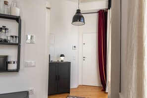 Una cocina moderna con un armario negro, una cafetera y una lámpara colgante negra.