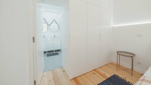 Une salle de bain moderne avec une paroi en verre, un miroir et une petite table.