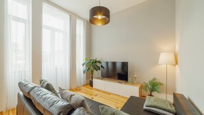 A modern living room with a sofa, TV, and plants. - Bonfim Premium by Hosty (Porto)