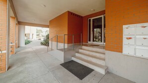 A covered outdoor area with a staircase leading to a door, a mailbox, and a concrete floor. - Matosinhos Premium by Hosty (Senhora da Hora)