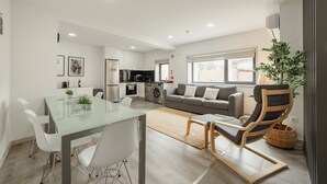 A modern apartment with a dining area, kitchen, living room, and a large window. - Amazing Villa by Hosty (Oporto)