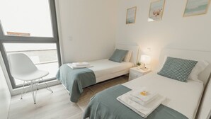 A hotel room with two beds, a chair, a small table, and a window. - Amazing Villa by Hosty (Oporto)