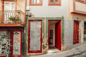 A building with a red door and a balcony with metal railings. - Charming Tiny House by Hosty (Porto)