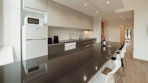 A modern kitchen with a central island, built-in appliances, and a dining area with bar stools.