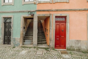 A building with numbered doors, a staircase, and a red door. - Modern Studio by Hosty (Porto)