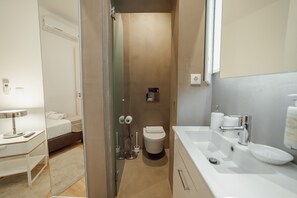 Une salle de bain équipée de toilettes, d’un bidet et d’un lavabo.