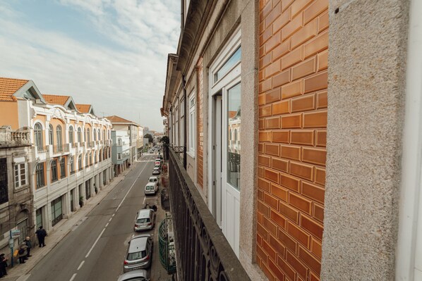 Une vue de rue avec des bâtiments, un ciel dégagé et des voitures garées.