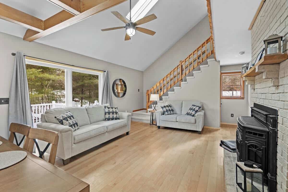 A spacious living area with a sofa, dining table, and staircase.