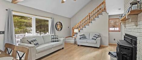 A spacious living area with a sofa, dining table, and staircase.
