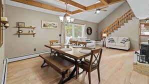 A spacious loft-style room with a dining area, a staircase, and a cozy seating area.