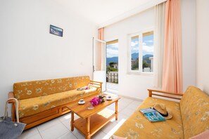 Apartment, 1 Bedroom, Balcony, Pool View | Living area | 75-cm flat-screen TV with digital channels