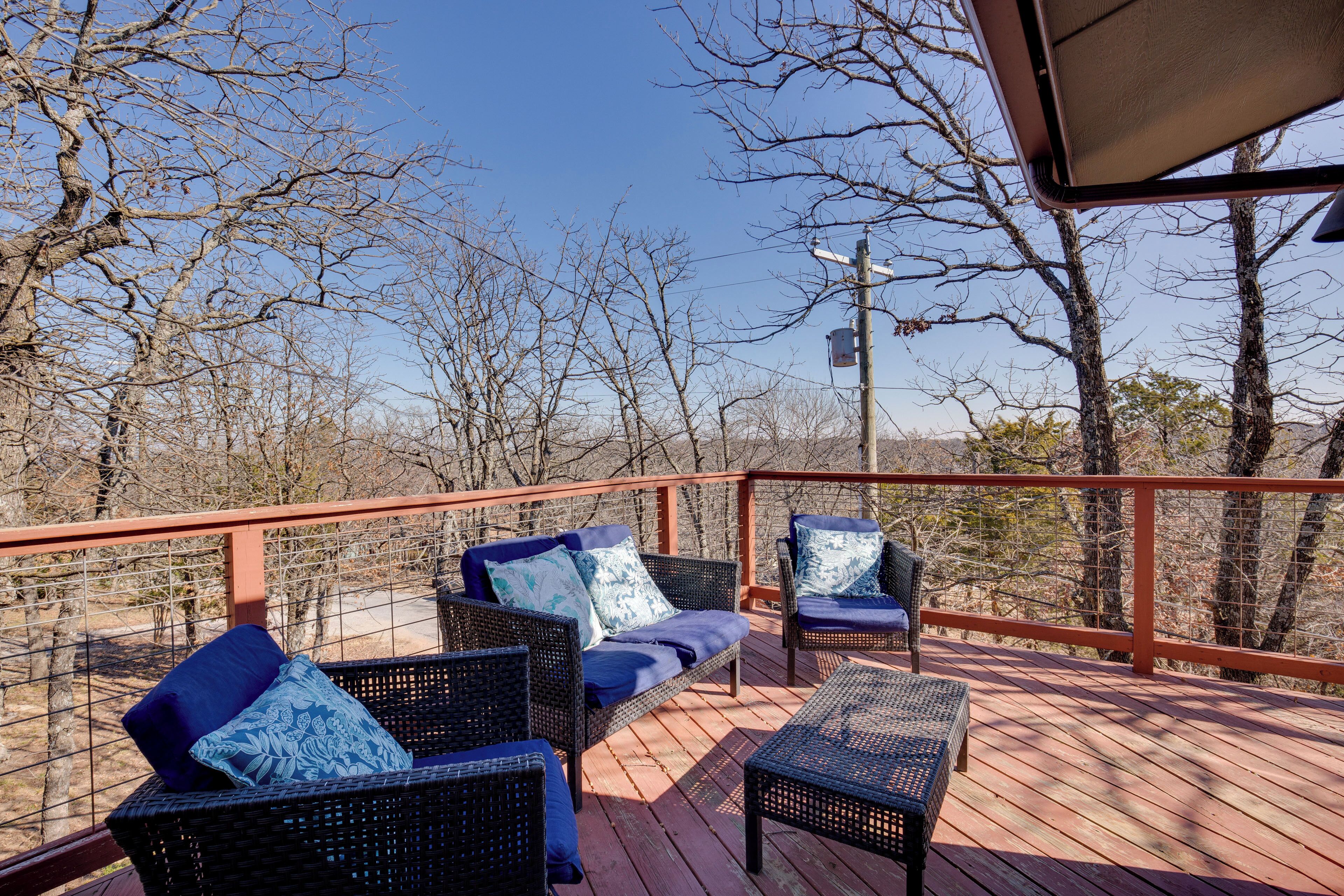 A wooden deck with wicker furniture and a metal railing.