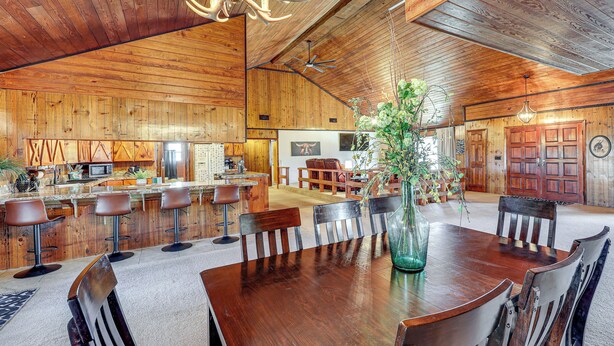 A spacious wooden interior with a large dining table, bar stools, and a chandelier. - 4 Mi to Lake Access: Pet-friendly Home in Bismarck (Bismarck)