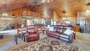 A spacious living area with leather sofas, a large rug, and a wooden staircase leading to an upper level. - 4 Mi to Lake Access: Pet-friendly Home in Bismarck (Bismarck)