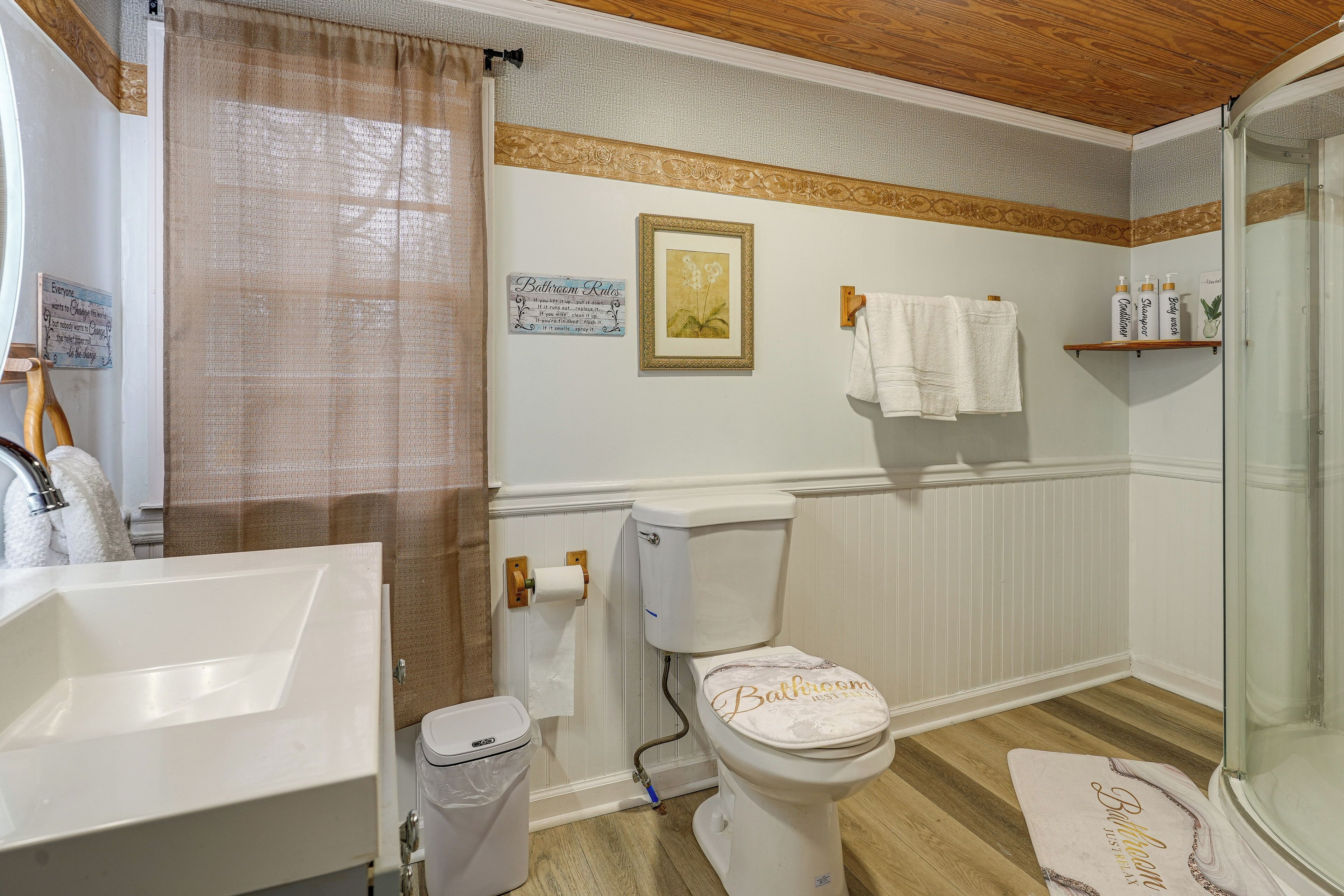 Une salle de bain comprenant des toilettes, un lavabo, une douche et un porte-serviettes.