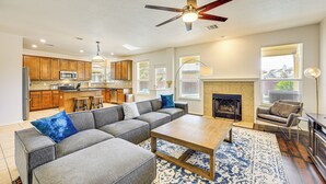 A modern living room with a sectional sofa, a coffee table, and a fireplace. - 5 Mi to Randolph Afb: Spacious Cibolo Haven! (Cibolo)