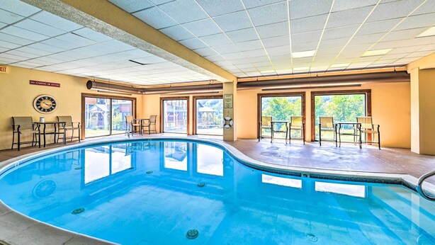 Une piscine intérieure équipée d’une horloge, de chaises et d’un panneau indiquant qu’il est interdit de sauter ou de plonger.