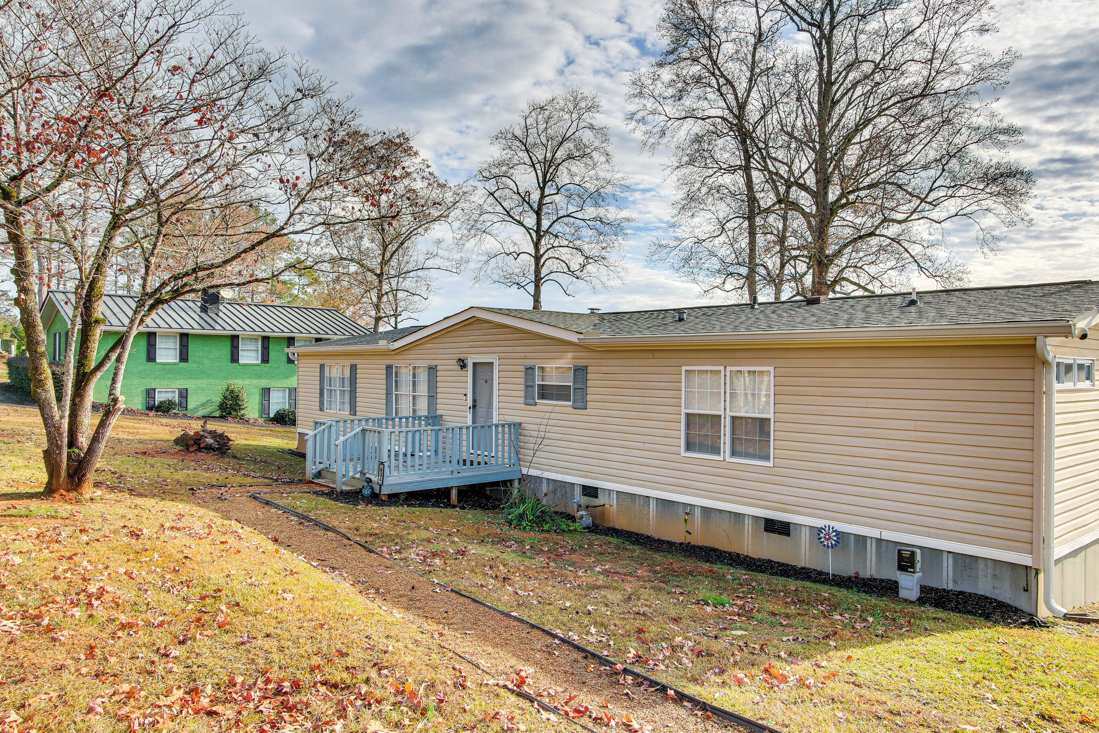 A row of mobile homes with a front porch and a small garden area.