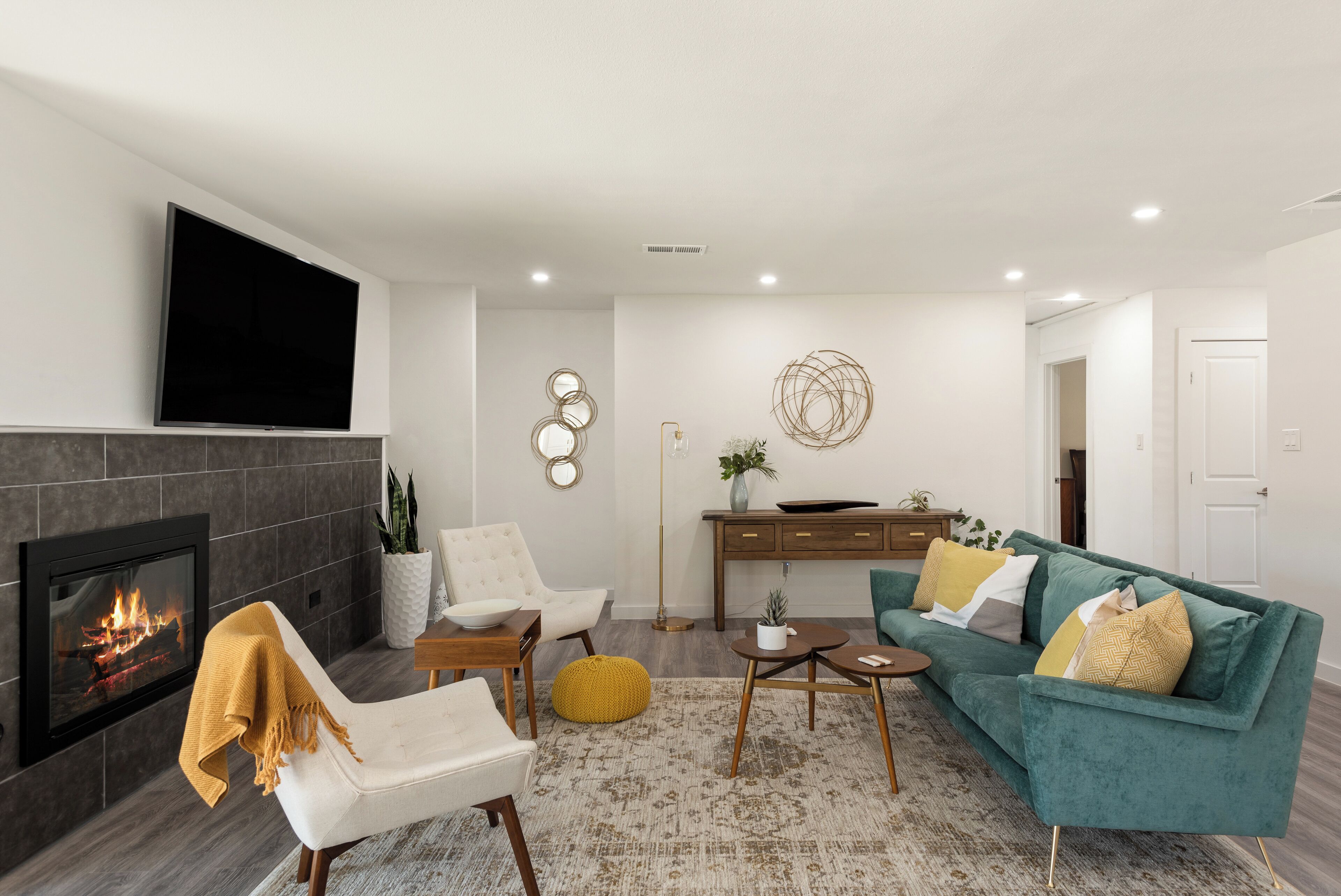 A modern living room with a fireplace, a sofa, a chair, and a coffee table.