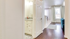 A hallway with a bathroom, a sofa, and a window with curtains. - 4 Mi to Dtwn: Family Home w/ Games in Frisco (Frisco)
