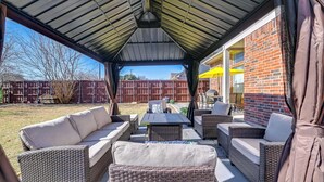 An outdoor patio with wicker furniture, a covered area, and a brick wall. - 4 Mi to Dtwn: Family Home w/ Games in Frisco (Frisco)