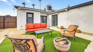 A patio with a sofa, chairs, and a fire pit. - 1 Mi to Grand Ave: Modern Home w/ Spacious Yard! (Phoenix)
