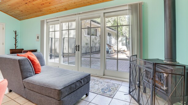 A cozy living room with a gray sofa, a fireplace, and a sliding glass door leading to a patio. - Drive to Major Parks: Nature Getaway in West Point (West Point)