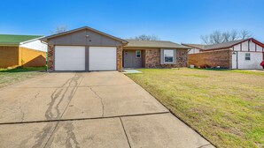 A residential house with a garage, brick exterior, and a well-maintained lawn. - 5 Mi to Fort Worth Stockyards: Home w/ Yard! (Haltom City)