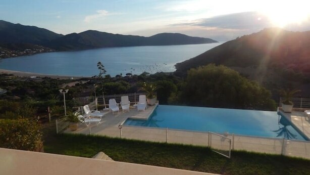 Una piscina con vistas a un lago y montañas.