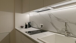 A modern kitchen with a marble backsplash, a built-in stove, and a sink with a faucet. - Liberty Suite - One Bedroom Apartment, Sleeps 2 (Piovene Rocchette)