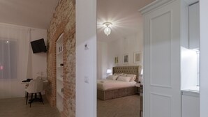 A bedroom with a bed, bedside tables, a desk, and a chair. - Liberty Suite - One Bedroom Apartment, Sleeps 2 (Piovene Rocchette)
