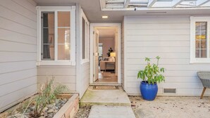 A house entrance with a welcome mat, a potted plant, and a chair. - Game room & Fire Pit, Close to Downtown! (Paso Robles)