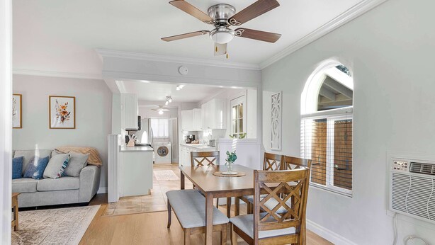A dining area with a wooden table and chairs, a ceiling fan, and a kitchen in the background. - Game room & Fire Pit, Close to Downtown! (Paso Robles)