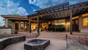 A covered outdoor patio with a fire pit, stone seating, and a pergola. - Private Movie Theater, Luxury Pool, Hot Tub (Scottsdale)