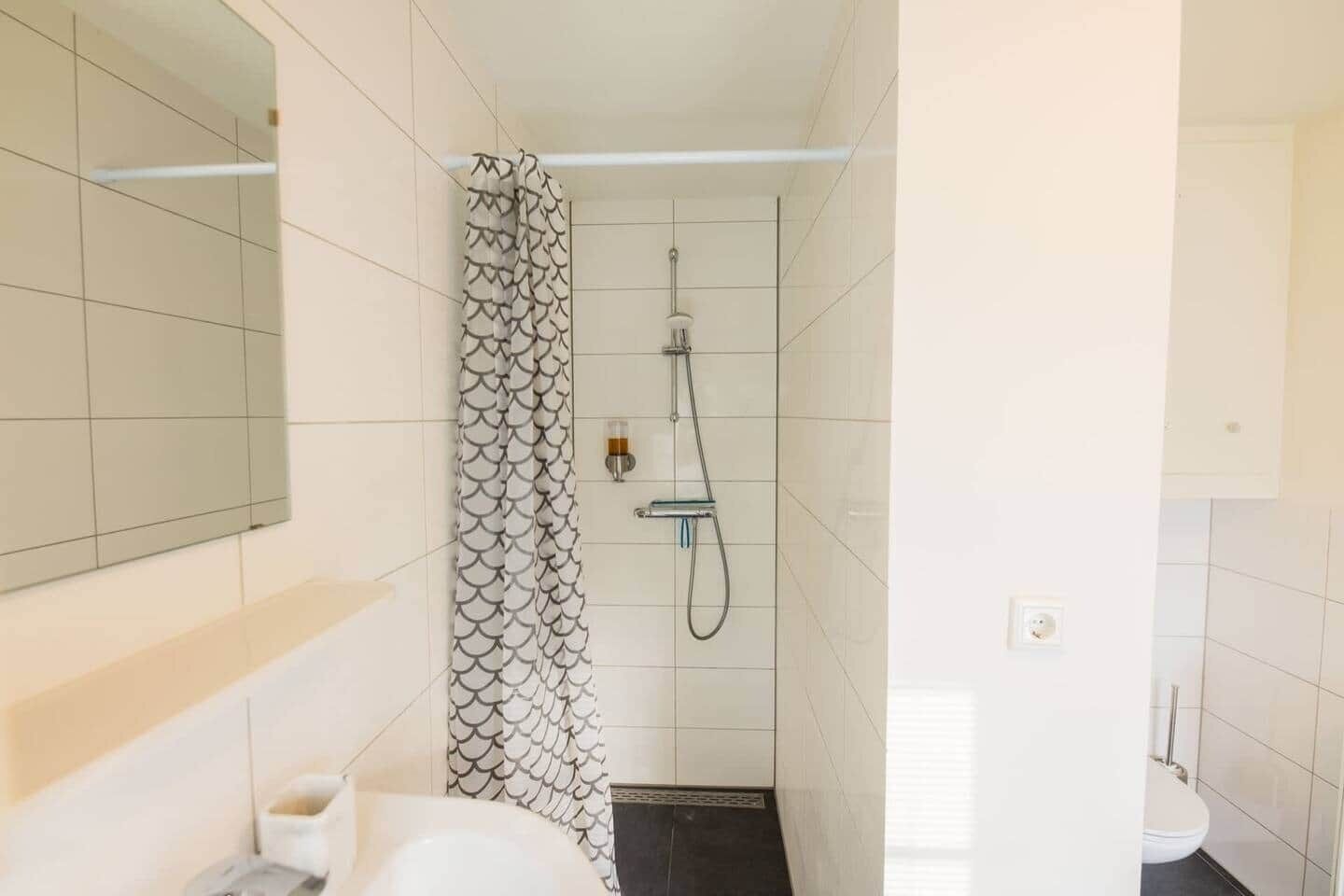 A bathroom with a shower, toilet, and sink.