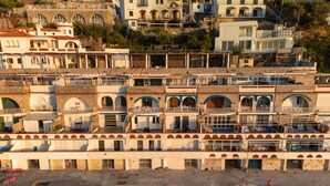 Un hôtel situé sur la côte, doté de nombreux balcons, d’une façade en pierre et offrant une vue sur la mer.