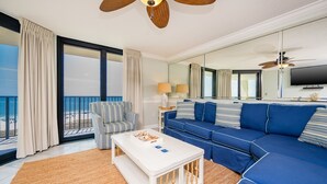 Ein modernes Wohnzimmer mit einem großen Sofa, einem gestreiften Sessel und einem weißen Couchtisch.