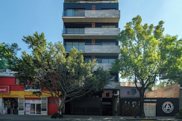 A multi-story building with a modern architectural design, featuring balconies and large windows.