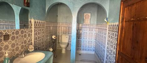 A bathroom with a sink, mirror, and arched alcoves.