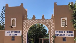 An entrance with signs reading "LES ETOILES DU KSAR" and "MAISON D'HÔTES RESTAURANT - PISCINE". - LES ETOILES DU KSAR (Mirleft)